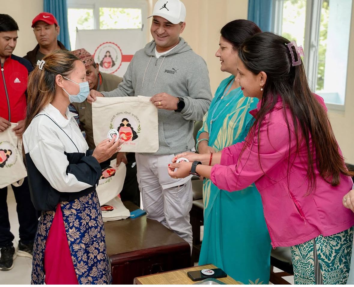 A badge and kit being handed to an expectant mother
